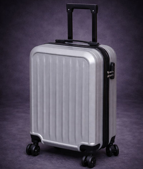 Silver suitcase with black handle and wheels on a dark purple background
