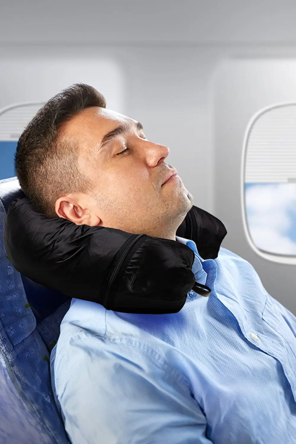 Man using a neck pillow on an airplane